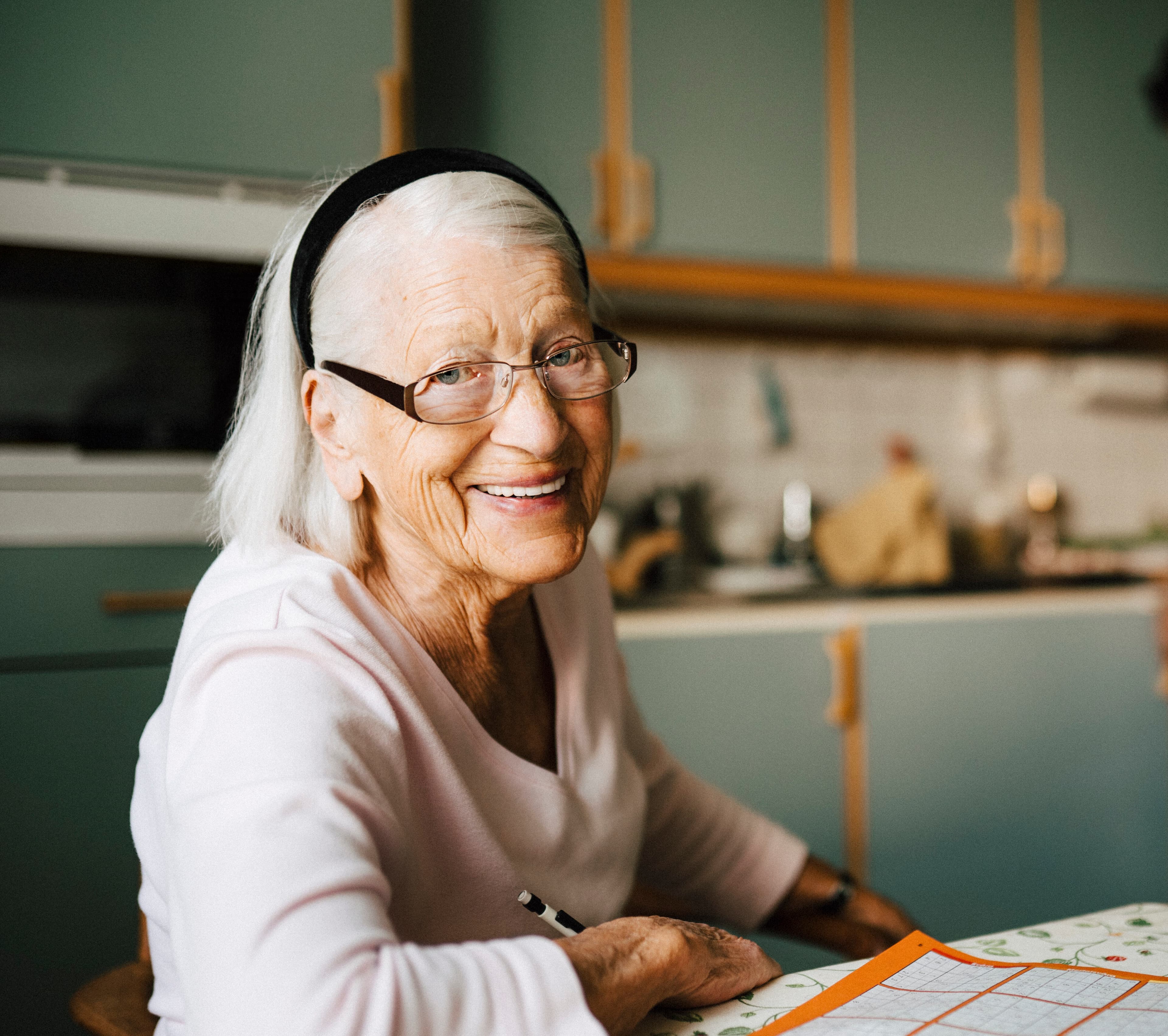 senior woman while male caregiver standing in background at home
