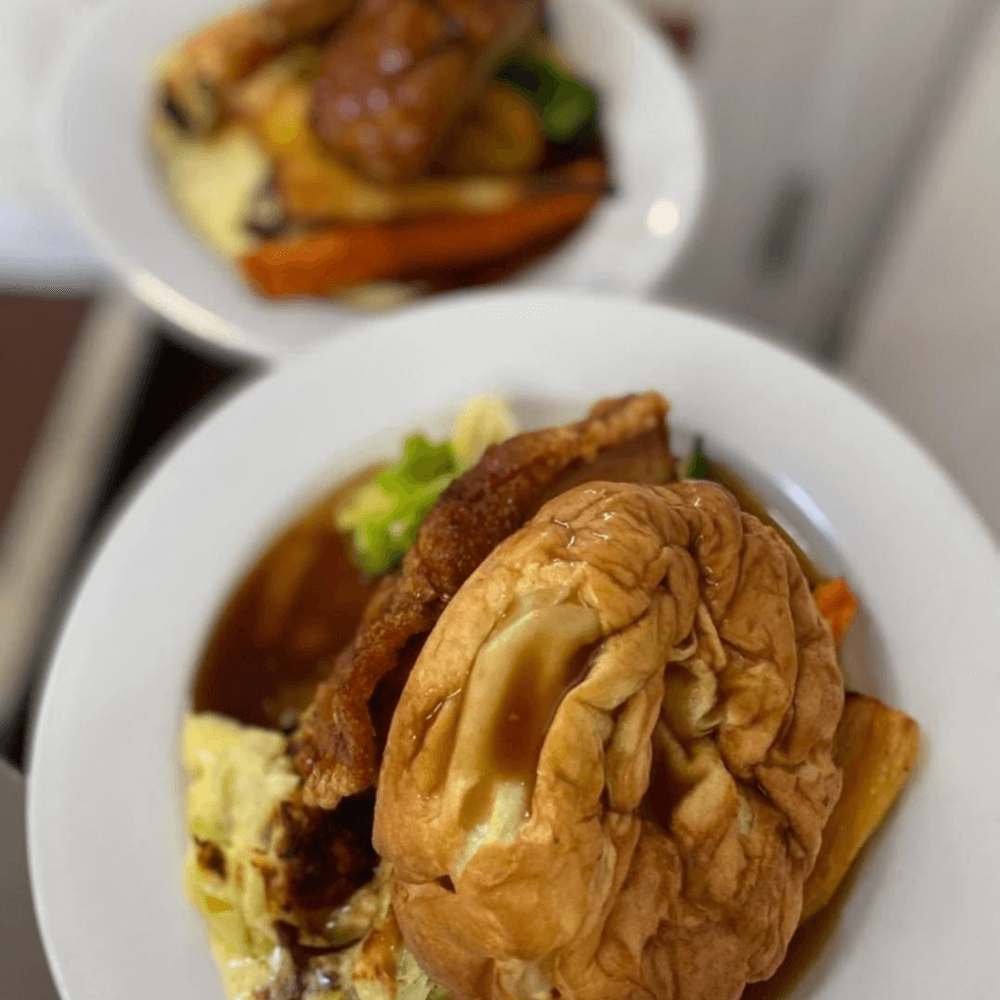 A plate with a traditional roast dinner including roast meat, Yorkshire pudding, and vegetables. - Home Instead
