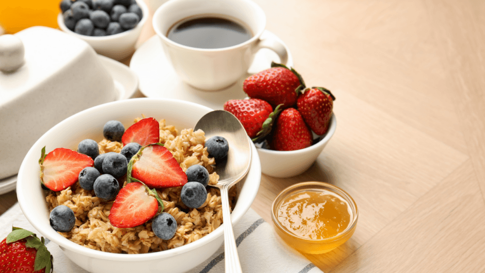 A healthy breakfast of coffee, fresh fruits such as strawberries and blueberries, yoghurt and granola - Home Instead Central Hampshire