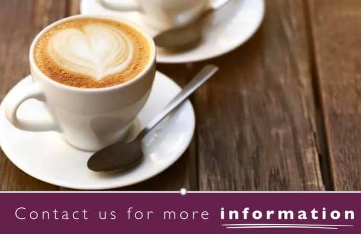 Two cups of coffee with heart-shaped foam art on a wooden table. Text at the bottom reads, "Contact us for more information. - Home Instead