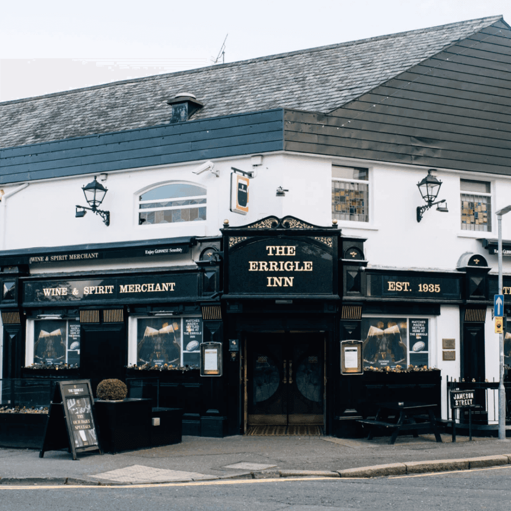 A traditional-looking pub named "The Errigle Inn," with vintage signage, located on a street corner. - Home Instead