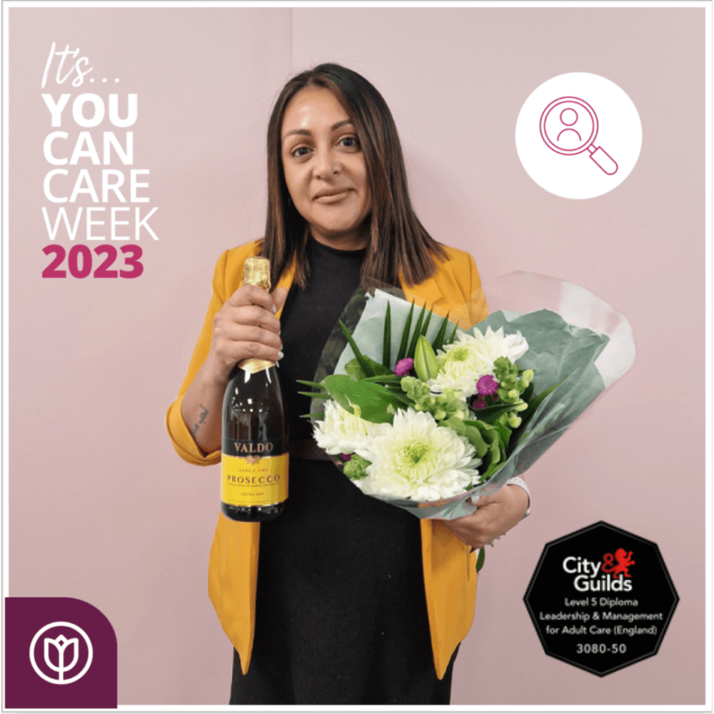 A woman holding flowers and a bottle of Prosecco celebrates "You Can Care Week 2023" with a City & Guilds diploma badge. - Home Instead