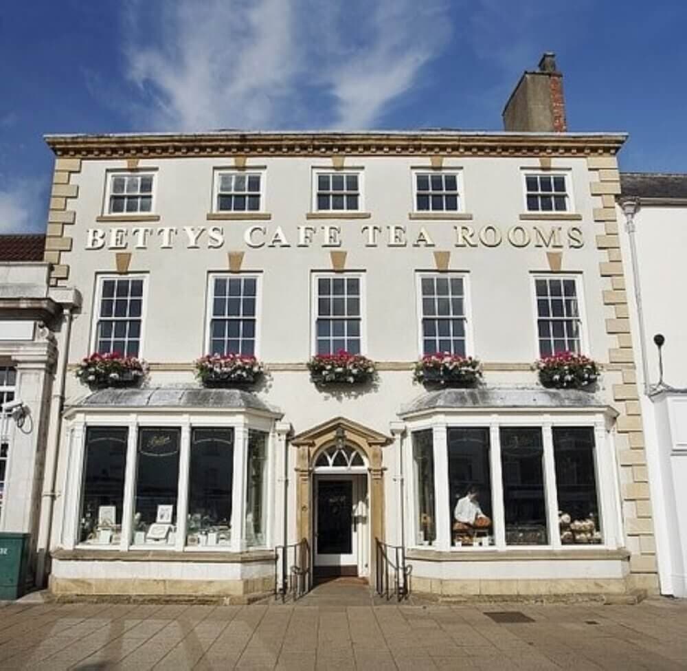 Facade of Betty's Café Tea Rooms, a historic building with large windows and floral decorations. - Home Instead