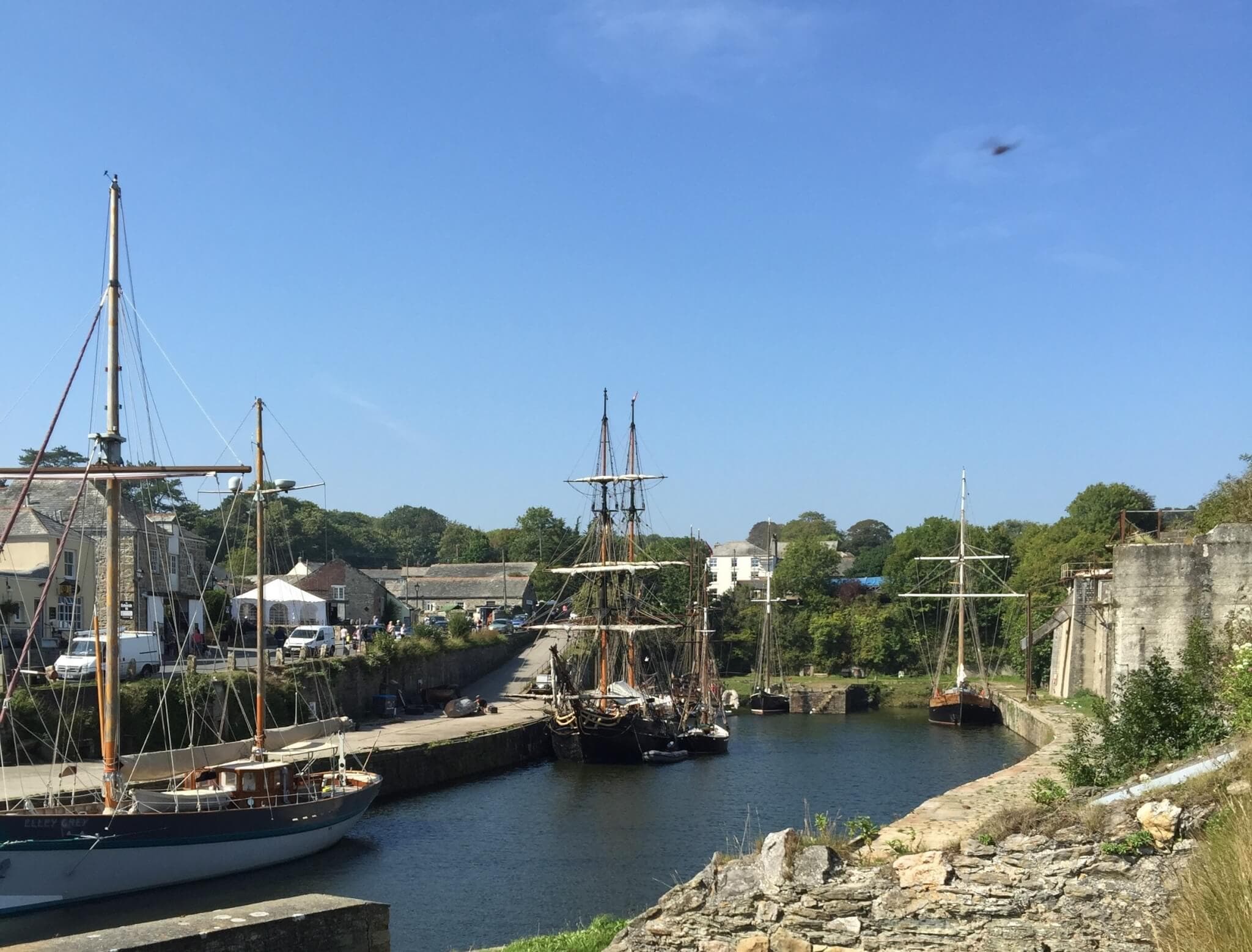 A picturesque harbor scene with sailing ships, historic buildings, and clear blue skies. - Home Instead