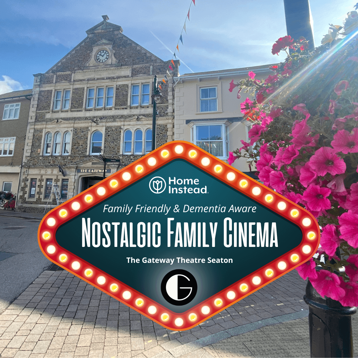 A sign reading "Nostalgic Family Cinema" in front of The Gateway Theatre Seaton, with flowers and buildings in the background. - Home Instead