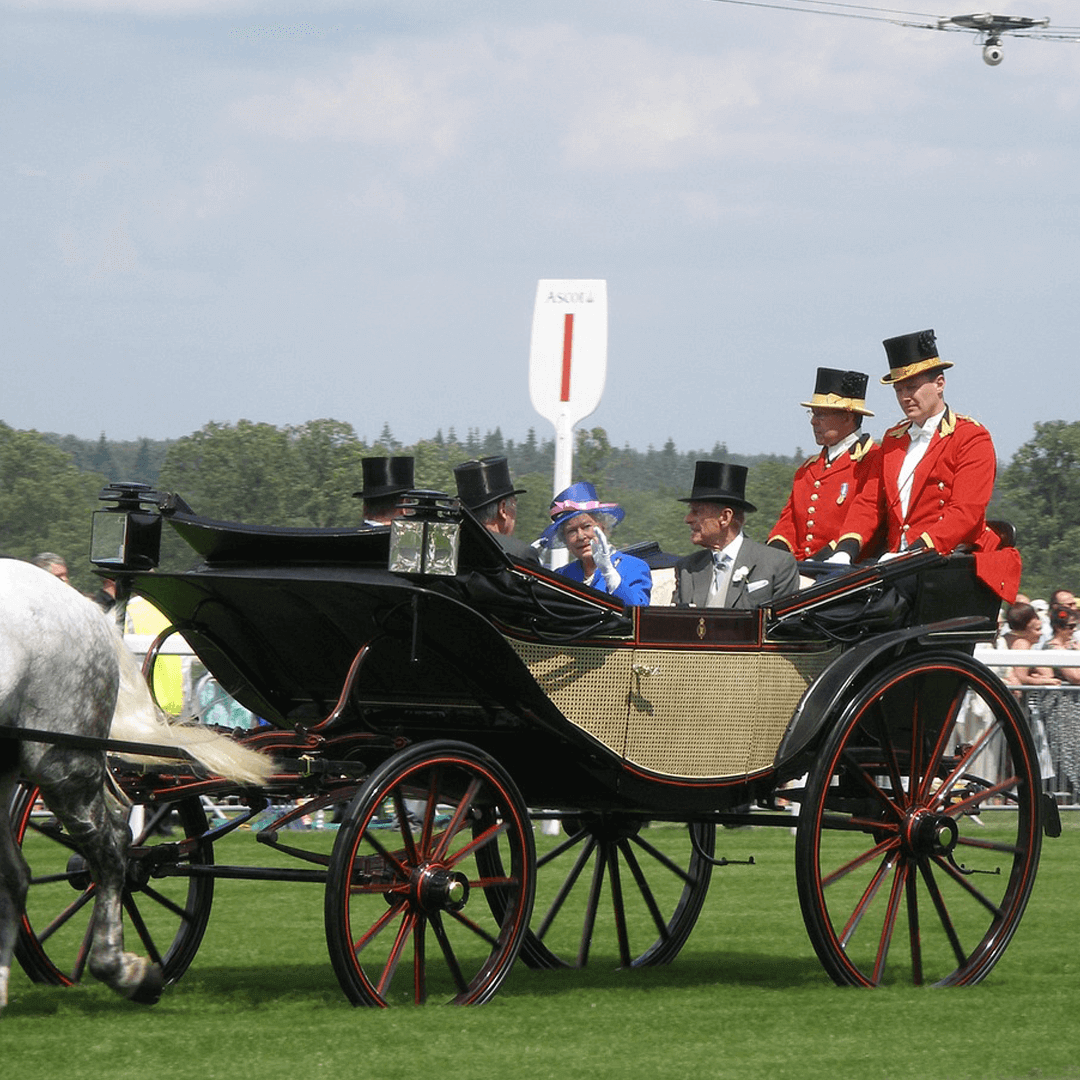 A horse-drawn carriage with people in formal attire, including top hats and uniforms, at an outdoor event. - Home Instead