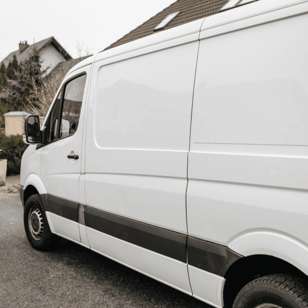White cargo van parked on a residential street in front of houses. - Home Instead