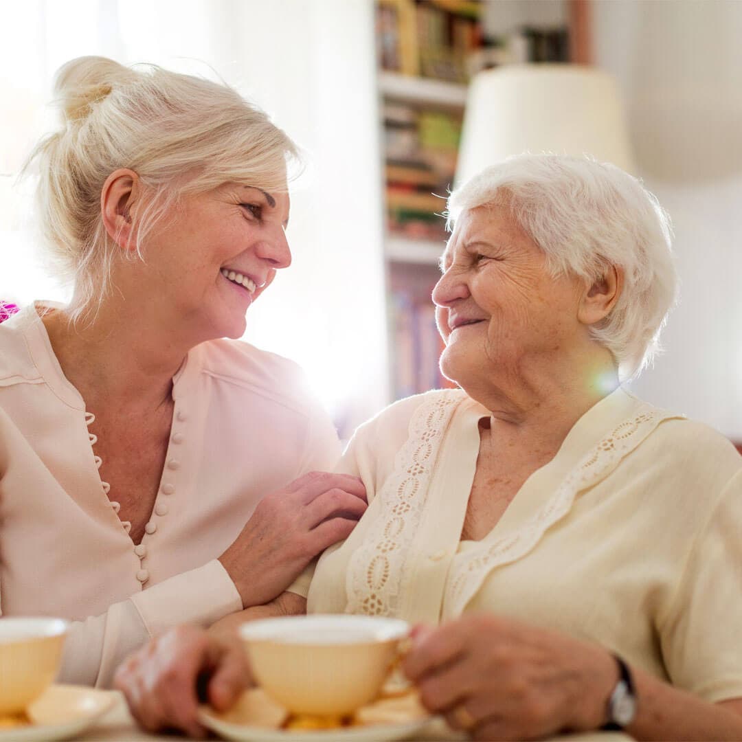 elderly mum and daughter sitting and chatting together