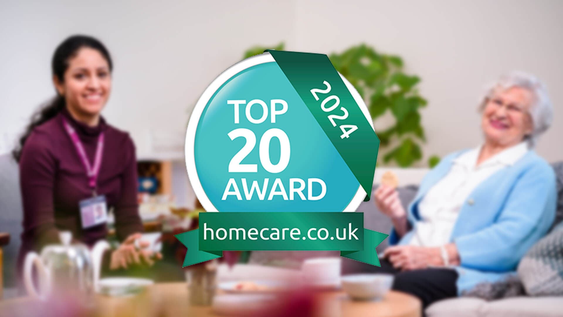 Two women sit and smile in a living room, with a "Top 20 Award 2024" badge from homecare.co.uk prominently displayed. - Home Instead
