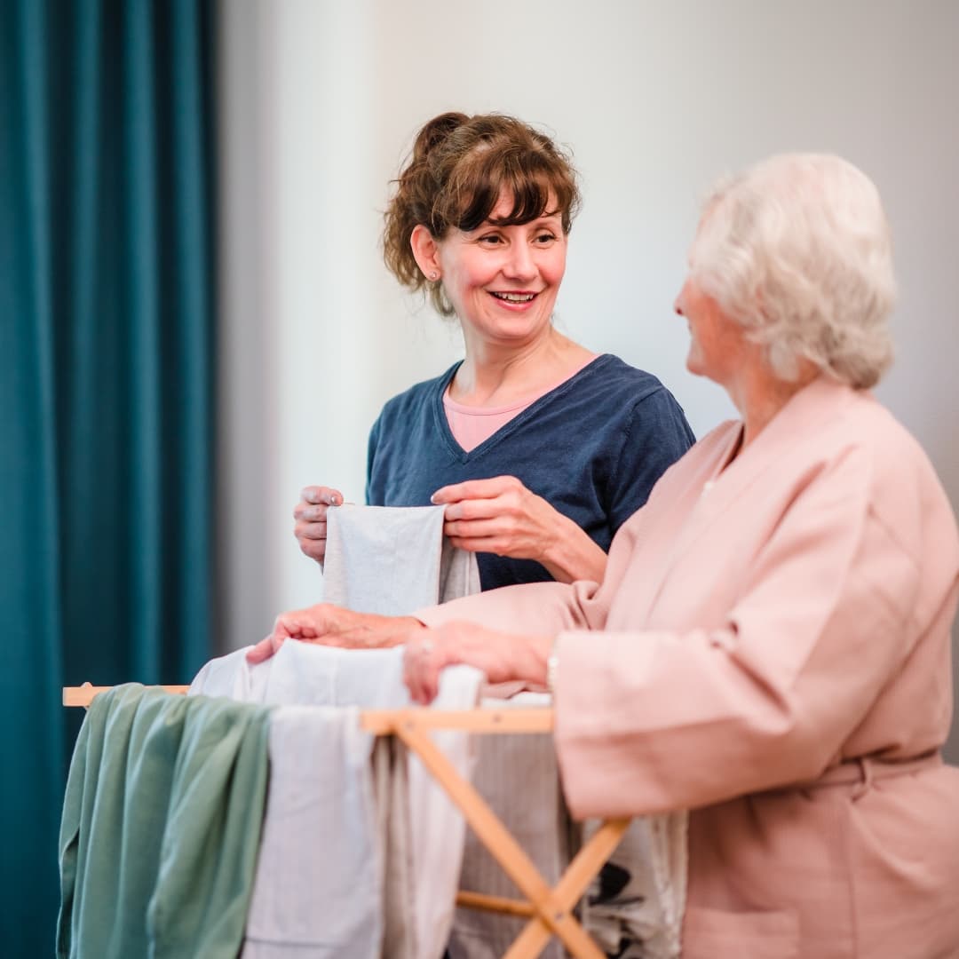 Care Professional and a client doing some ironing