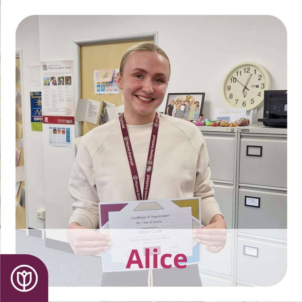 Smiling person holding a "Certificate of Appreciation" in an office setting. - Home Instead