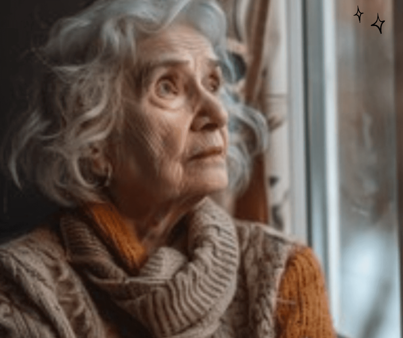 Elderly woman with white hair gazing out a window, wearing a chunky knit sweater. - Home Instead