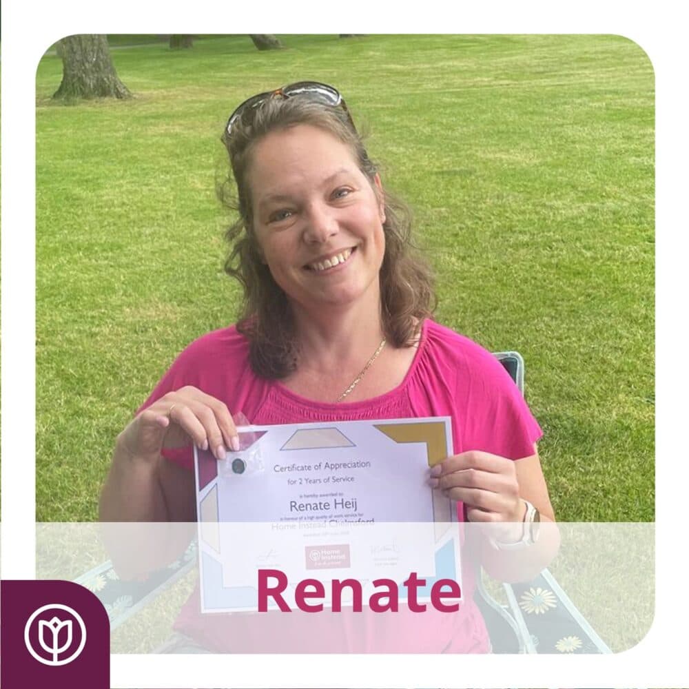 A person sitting outdoors, smiling and holding a certificate of appreciation. - Home Instead