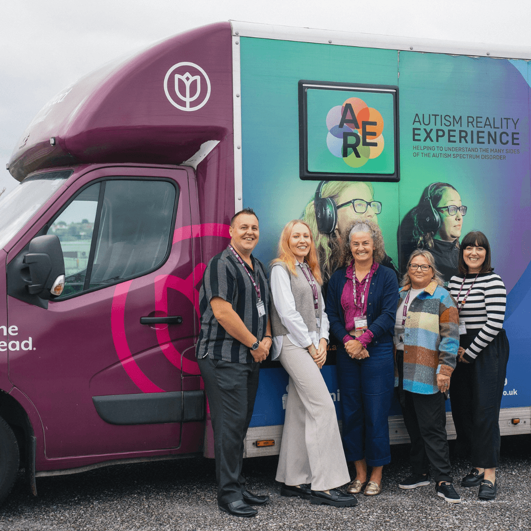 Home Instead staff stood outside the autism reality experience bus