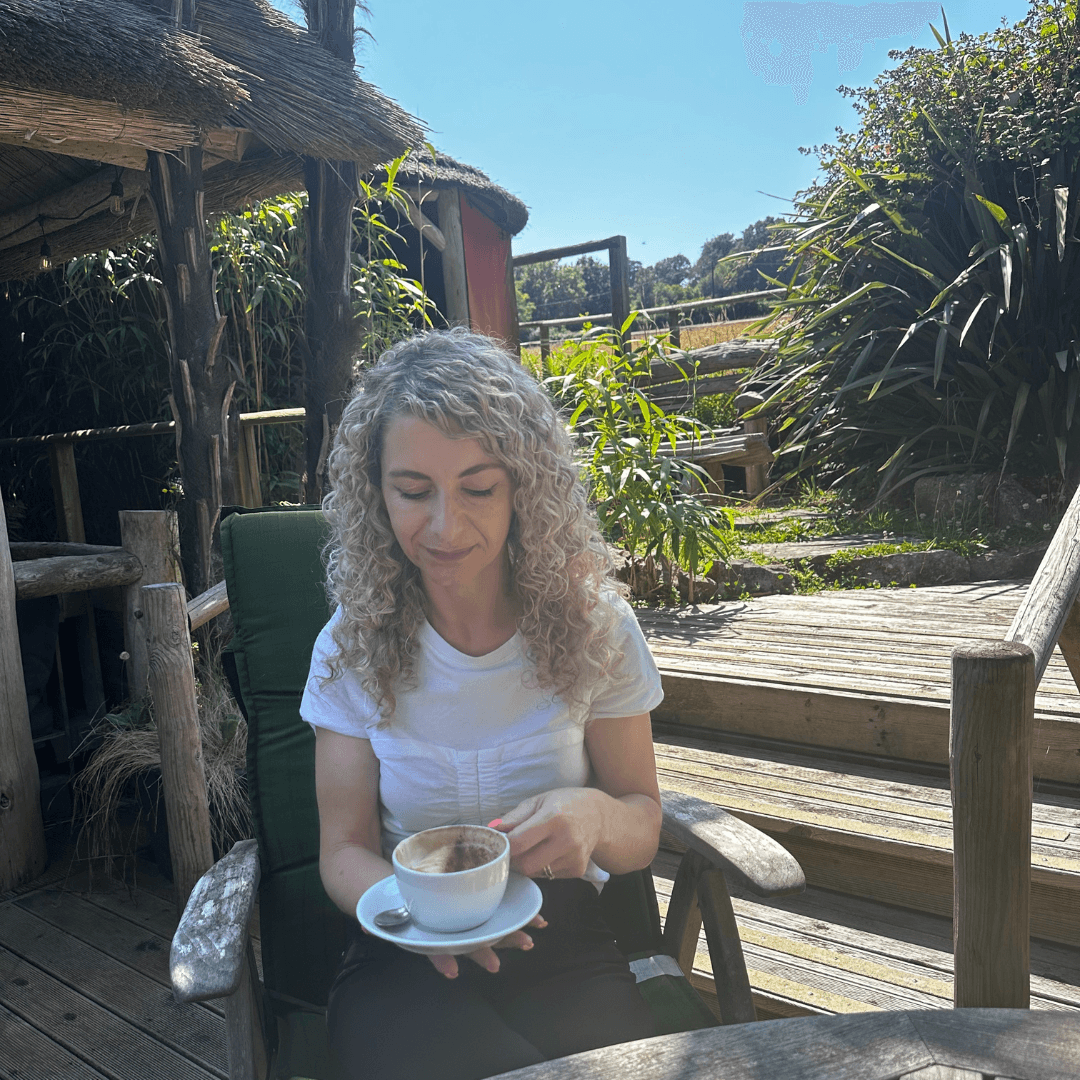 Sarah drinking a coffee sat outside