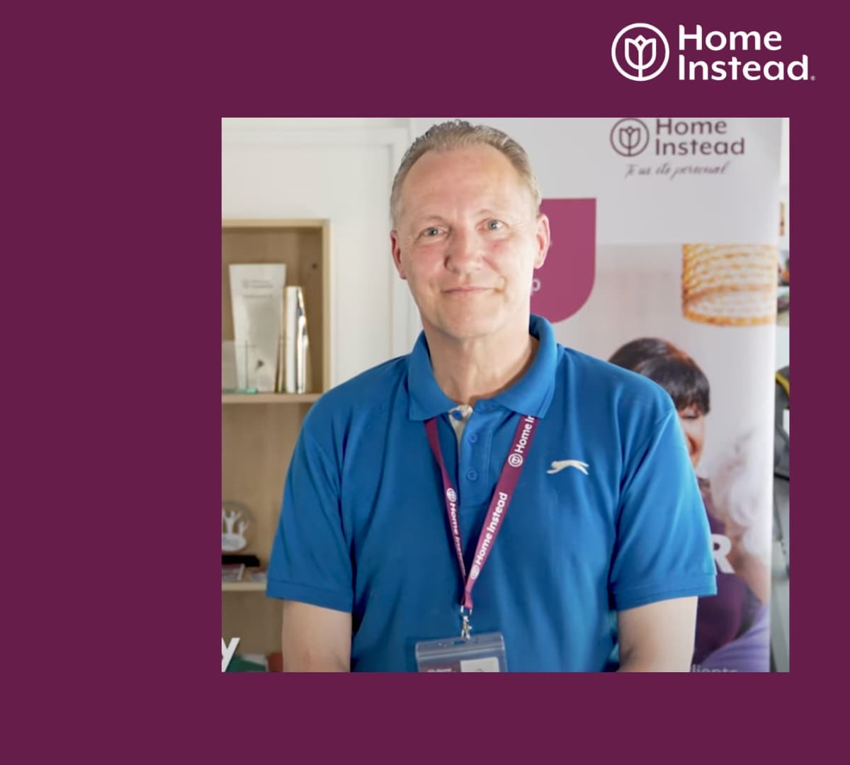 A male carer inside Home Instead office wearing a blue shirt with ID
