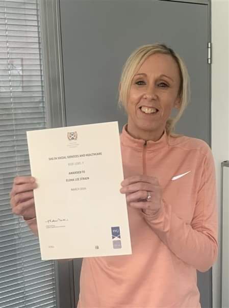 Care Professional holding her SVQ 3 certificate.