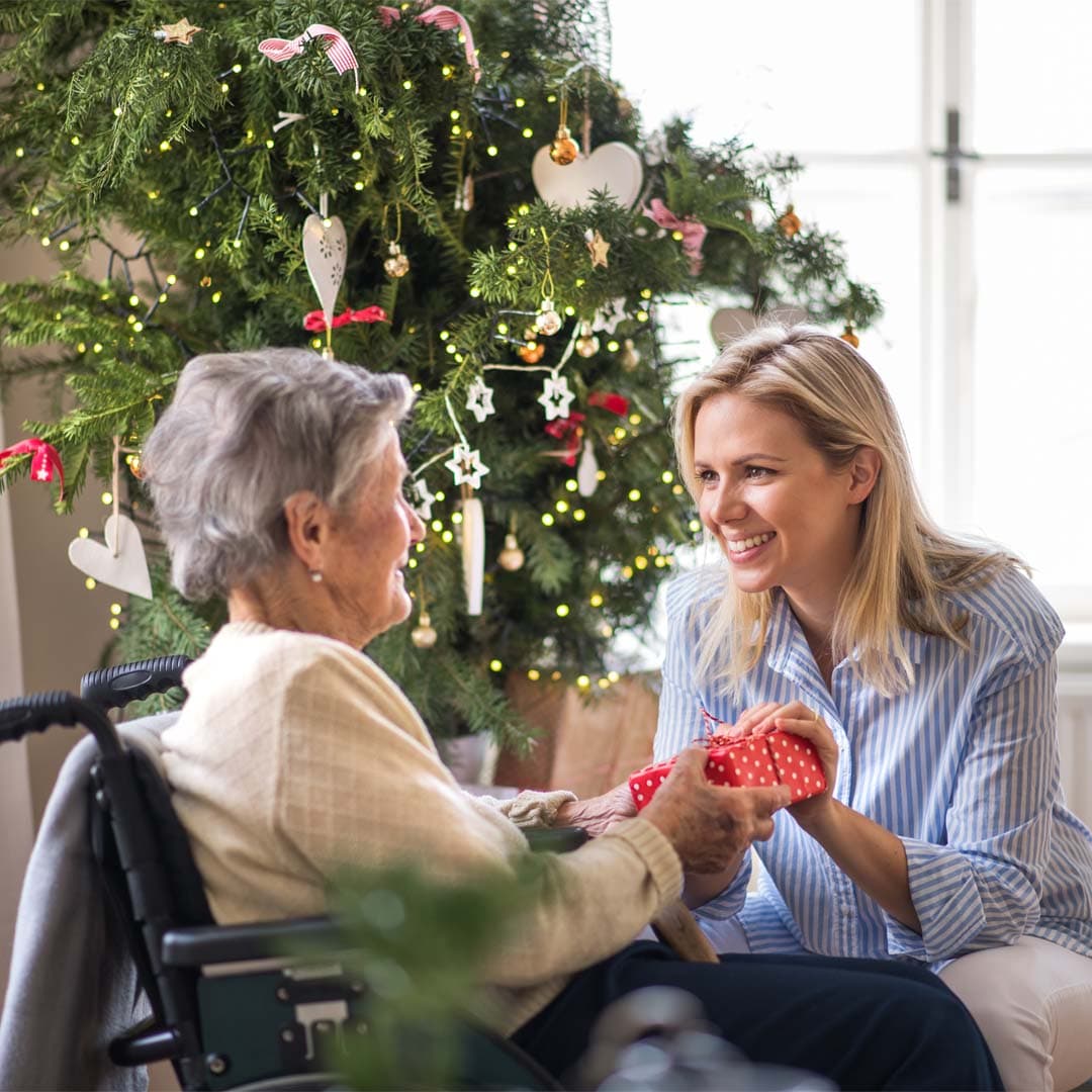 Home Instead Care professional sharing a gift at Christmas with her client