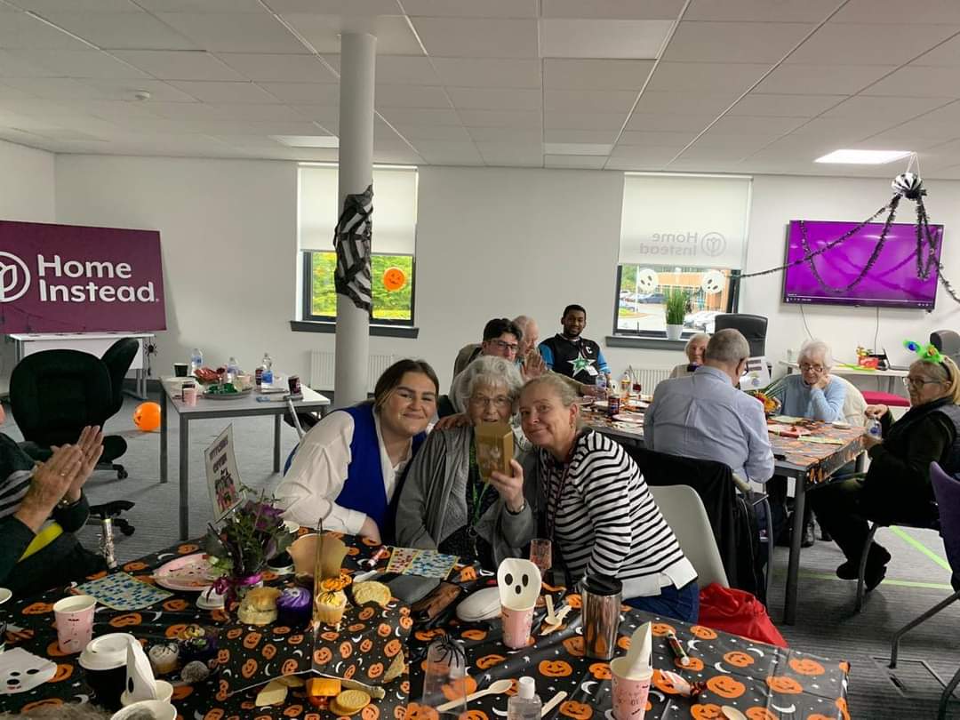 Care Professionals taking a picture with a client at the Halloween party.
