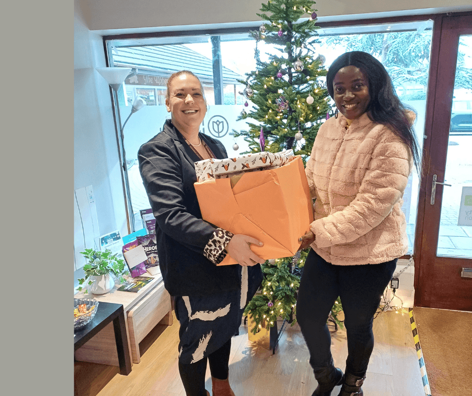 Home Instead Taunton recruiter Louisa handing over the Be A Santa gifts to Diversity Voice Uk team member