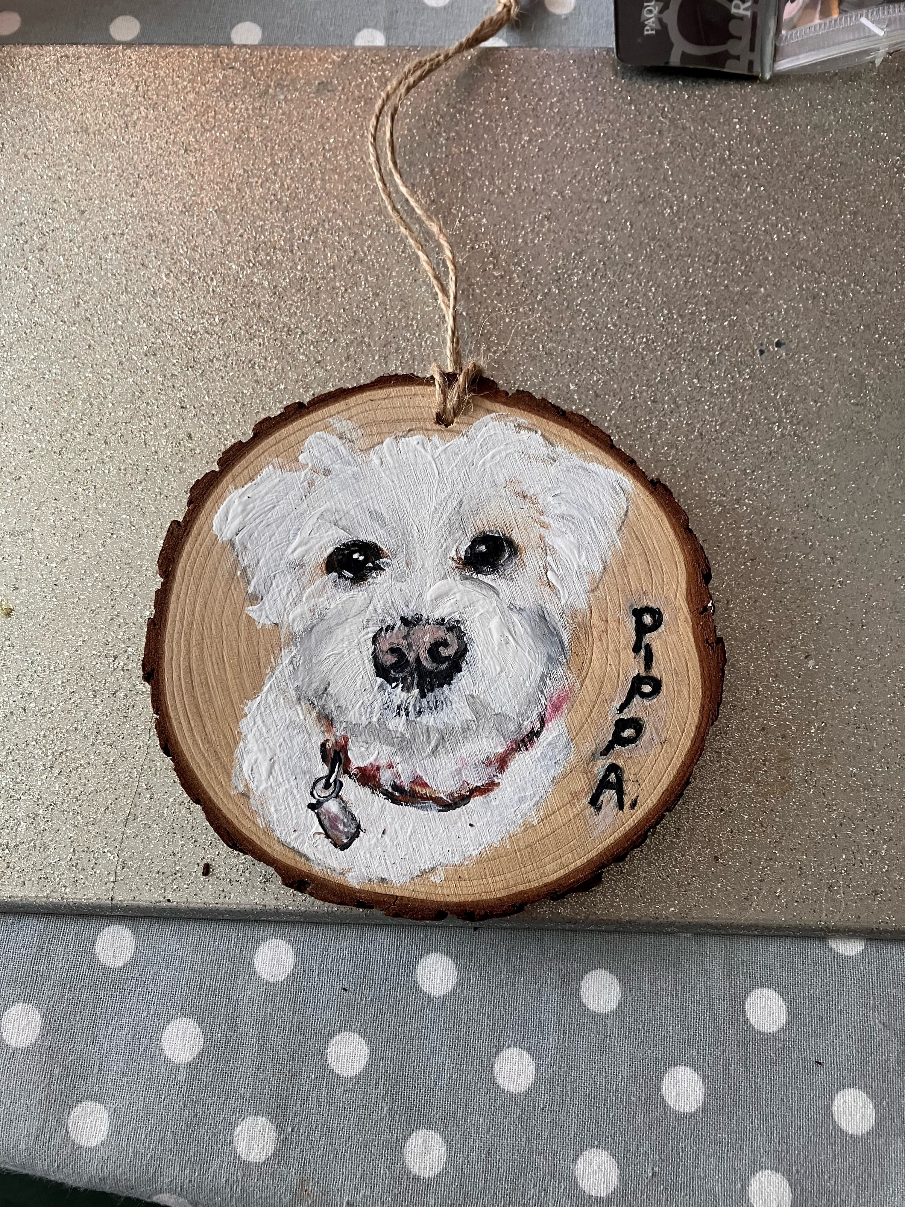 Hand painted image of a clients dog onto wood by a care professional