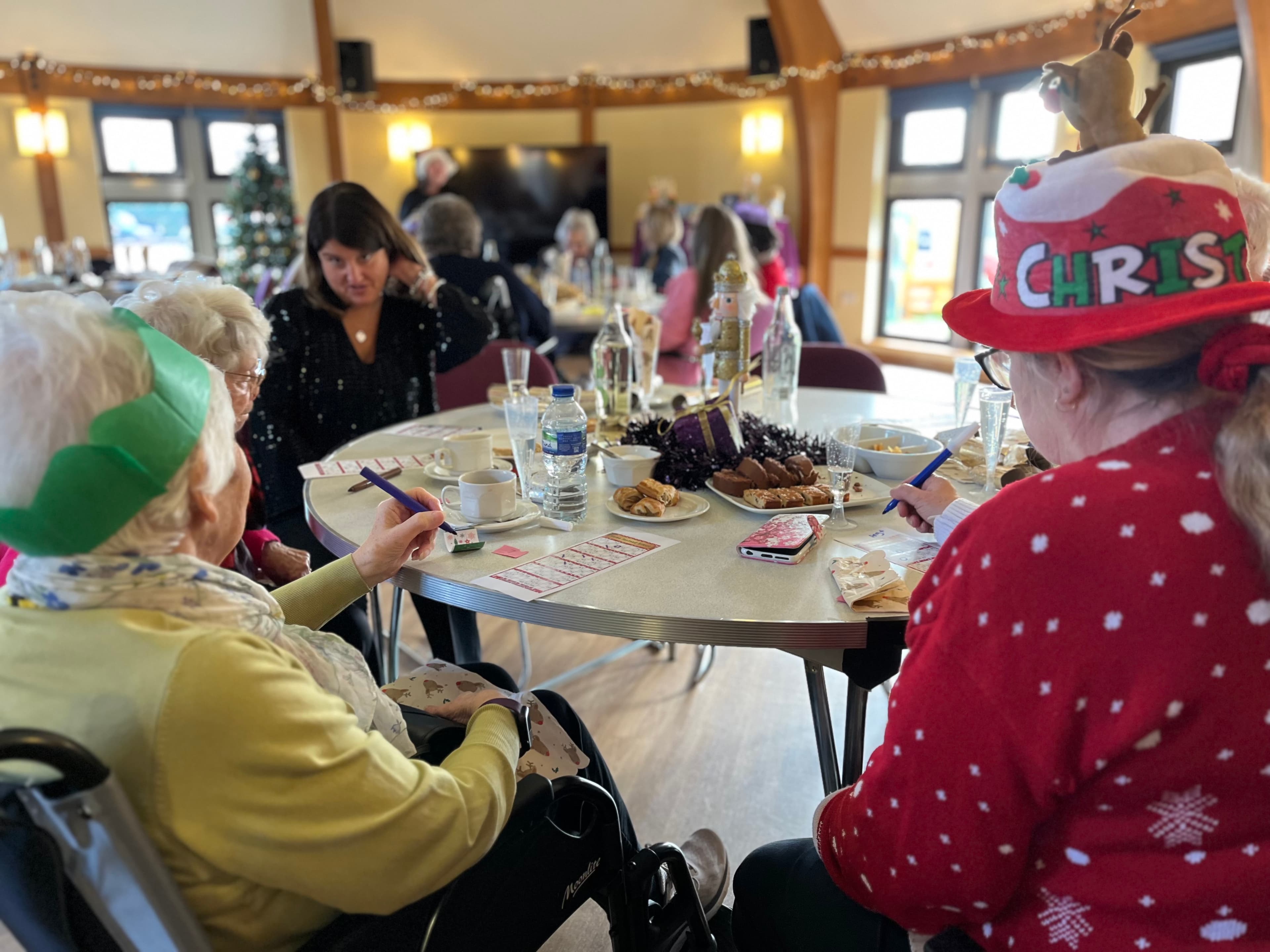 Client and care professionals enjoying Christmas party food and drinks.