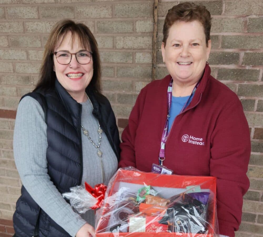 Two women holding a hamper both happy and smiling