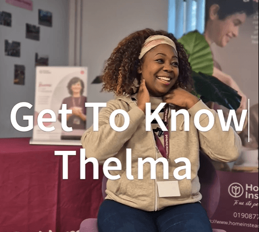 A smiling woman sits indoors with the text “Get To Know Thelma” over the image. - Home Instead
