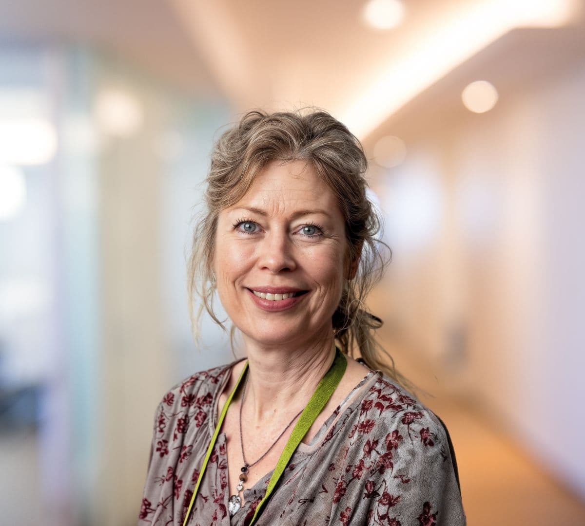 A woman with brown hair smiling inside the office