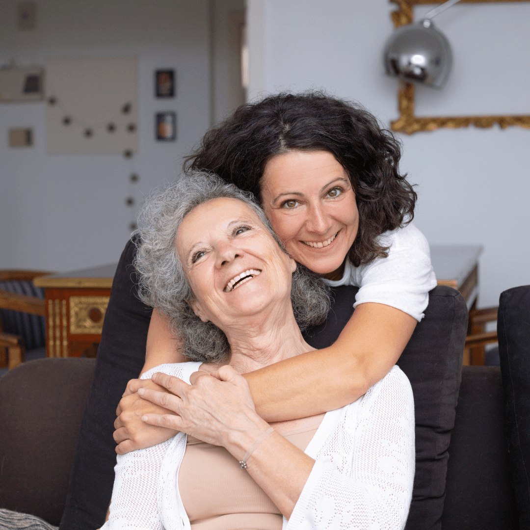 two women hugging, one with black hair ad the other with grey hair