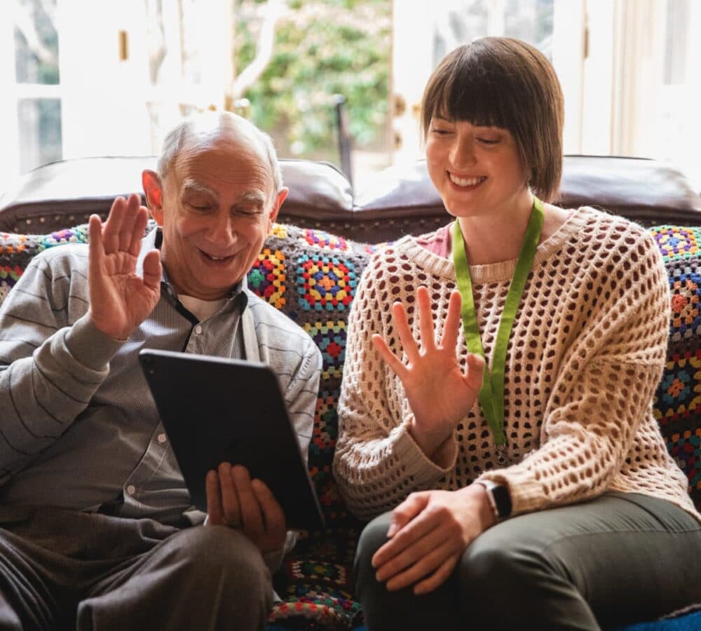 Two people having video calls while using an ipad inside the house both happy and smiling