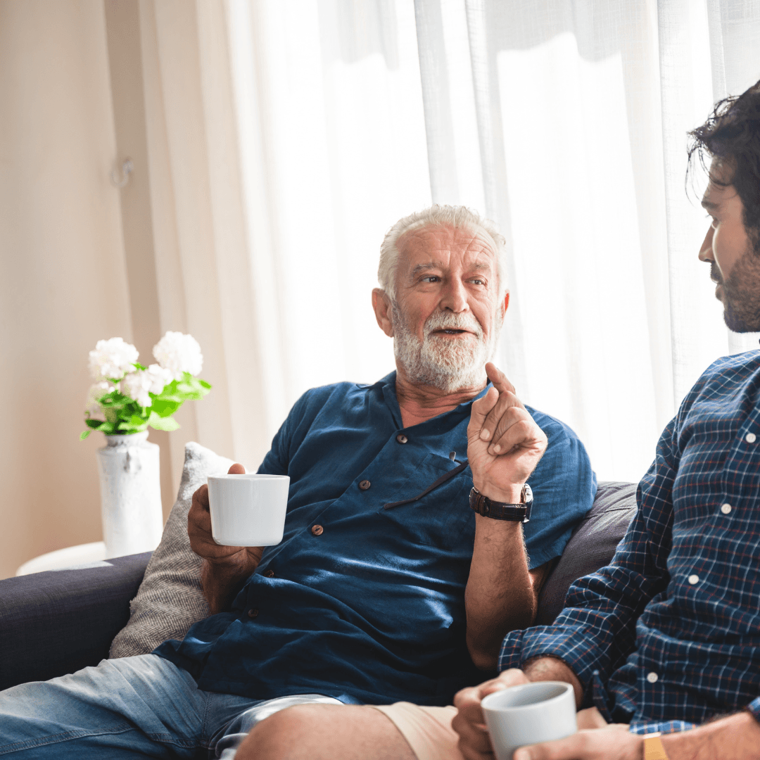 Two men with cups of coffee, talking
