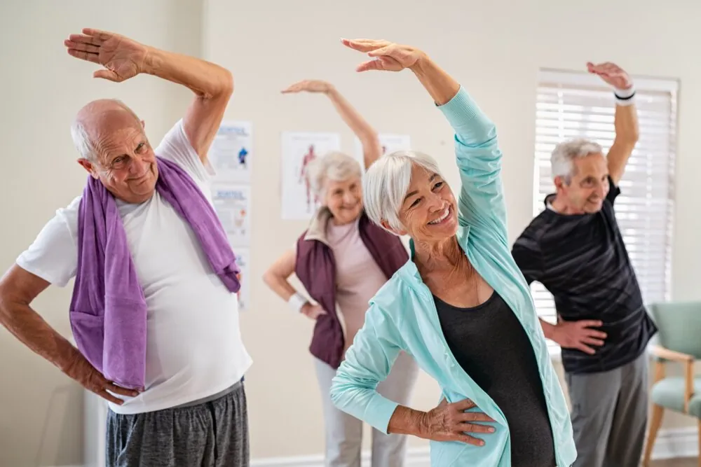 Group exercise class for older adults doing their stretching exercises