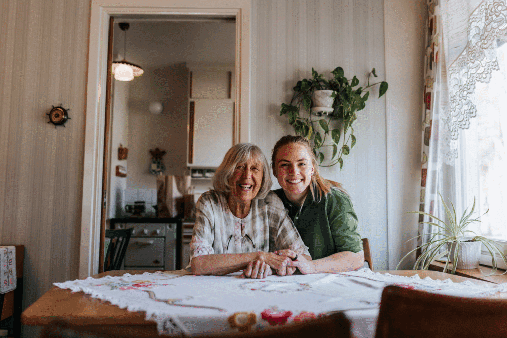 Home Instead Care Professional smiling with an elderly female client in her own home