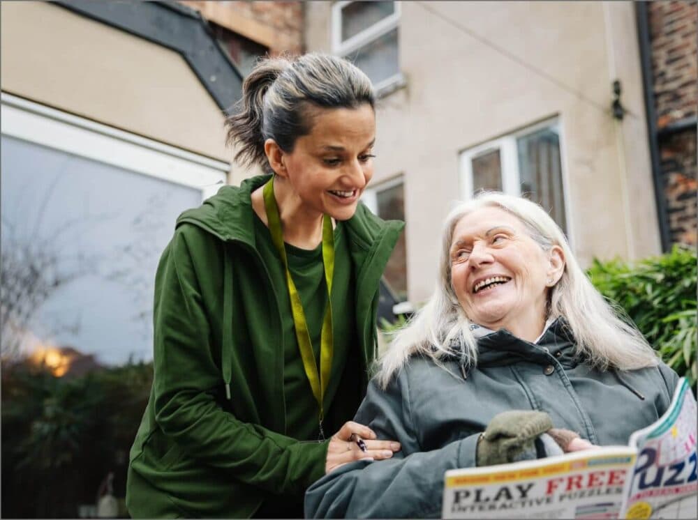 Home Instead care professional laughing together with her client