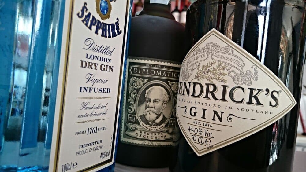 Bottles of Sapphire gin, Diplomatico rum, and Hendrick's gin placed next to each other on a shelf. - Home Instead