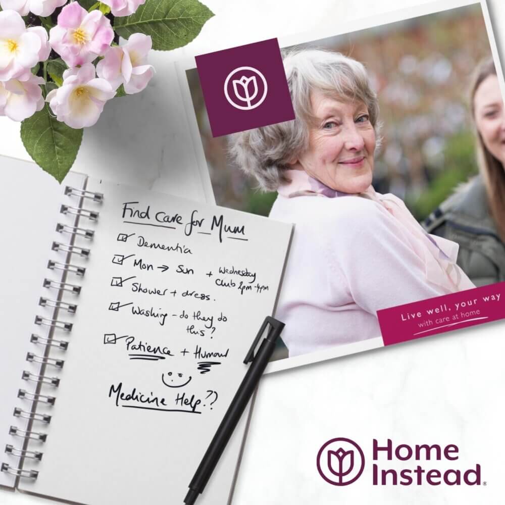 A notebook with care notes, a pen, flowers, and a Home Instead flyer featuring an elderly woman smiling. - Home Instead