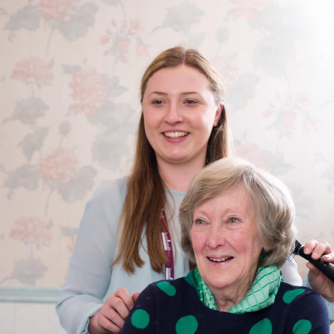 Home Instead carer brushing the hair of her Home Instead client