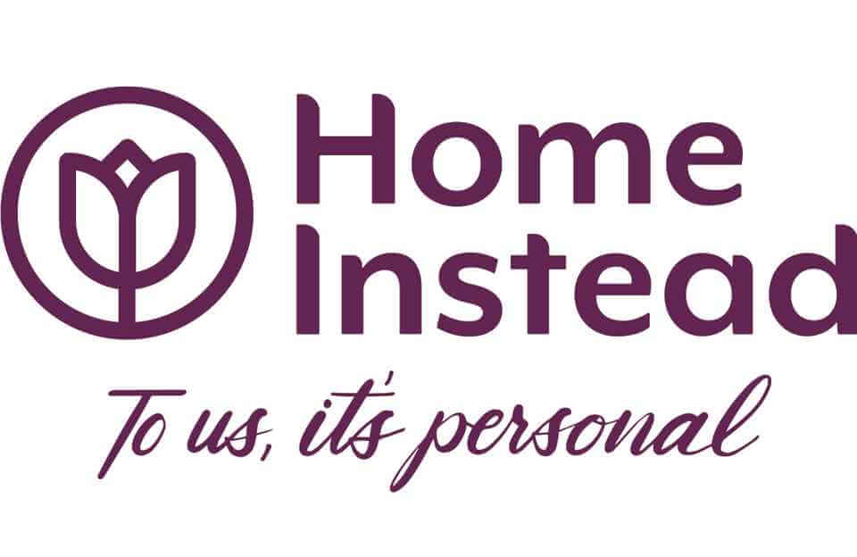 Logo of Home Instead featuring a stylized flower and the text "Home Instead" and "To us, it's personal. - Home Instead
