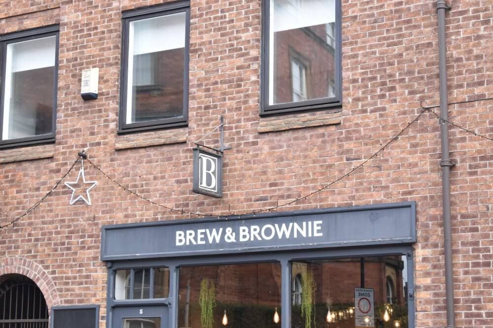 A brick building with a sign that reads "Brew & Brownie" and a hanging light decoration shaped like a star. - Home Instead