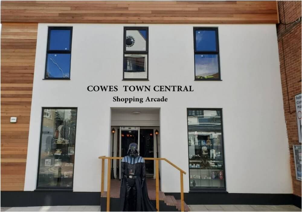 Entrance of Cowes Town Central Shopping Arcade, with a Darth Vader statue standing before the stairs leading inside. - Home Instead
