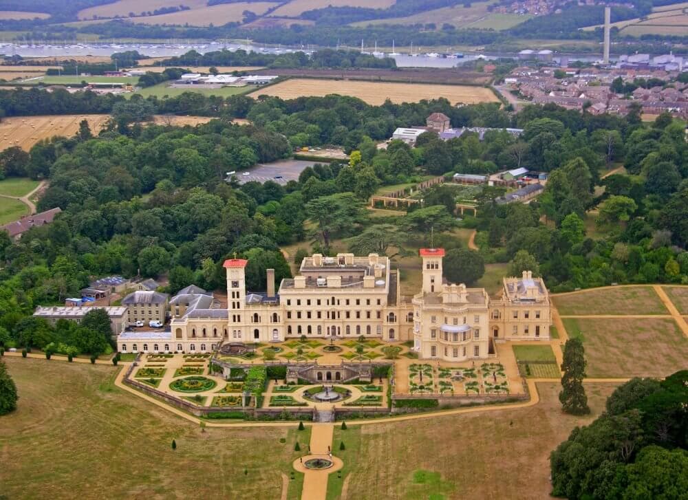 Aerial view of Osborne House, an estate with extensive gardens and surrounding greenery on the Isle of Wight. - Home Instead