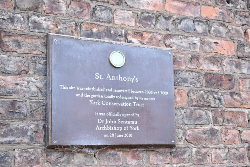 Plaque on a brick wall with information about the refurbishment of St. Anthony's site and its opening in June 2010. - Home Instead