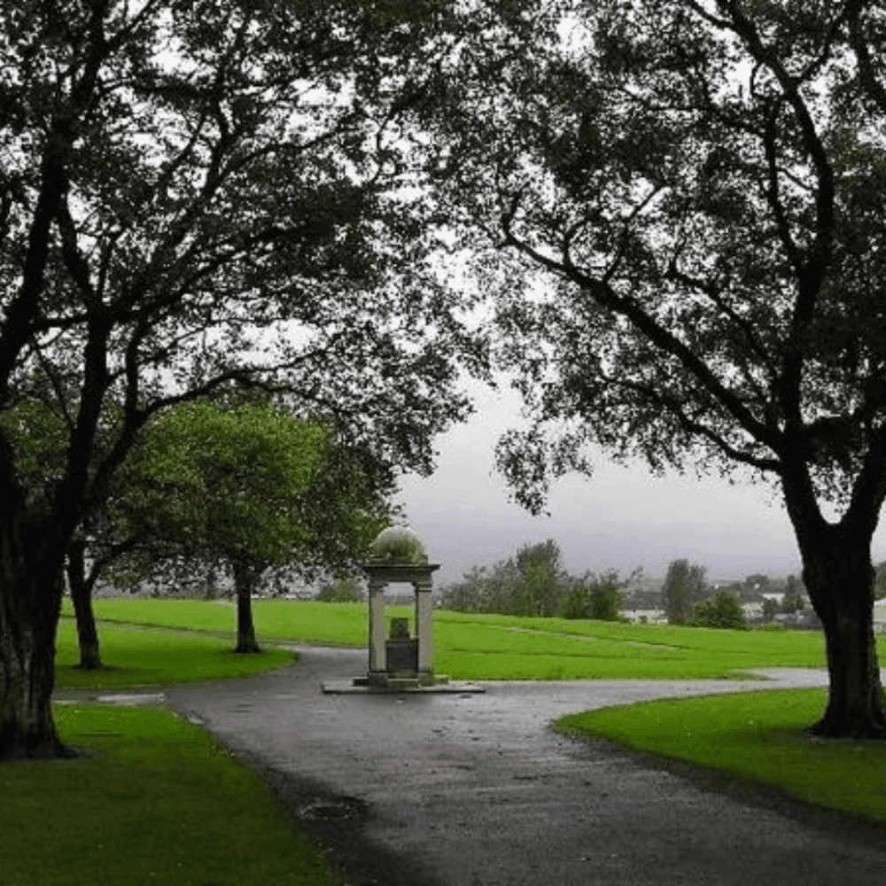 Thomas Shanks Park - A park with a central monument, flanked by trees, with overcast skies and green lawns. - Home Instead Renfrewshire and Barrhead home care services