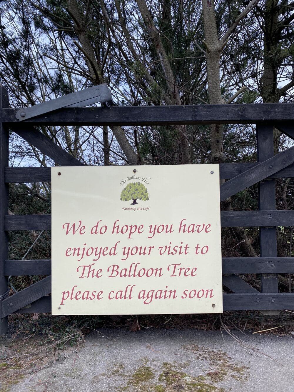 Sign on a wooden gate reads, "We do hope you have enjoyed your visit to The Balloon Tree, please call again soon. - Home Instead