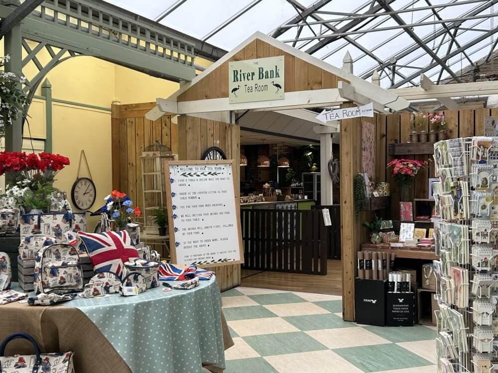 Home Instead Basingstoke picture of the entrance to River Bank Tea Room at Conkers Garden Centre, Basingstoke, showing gift items like bags, mugs, and greeting cards.