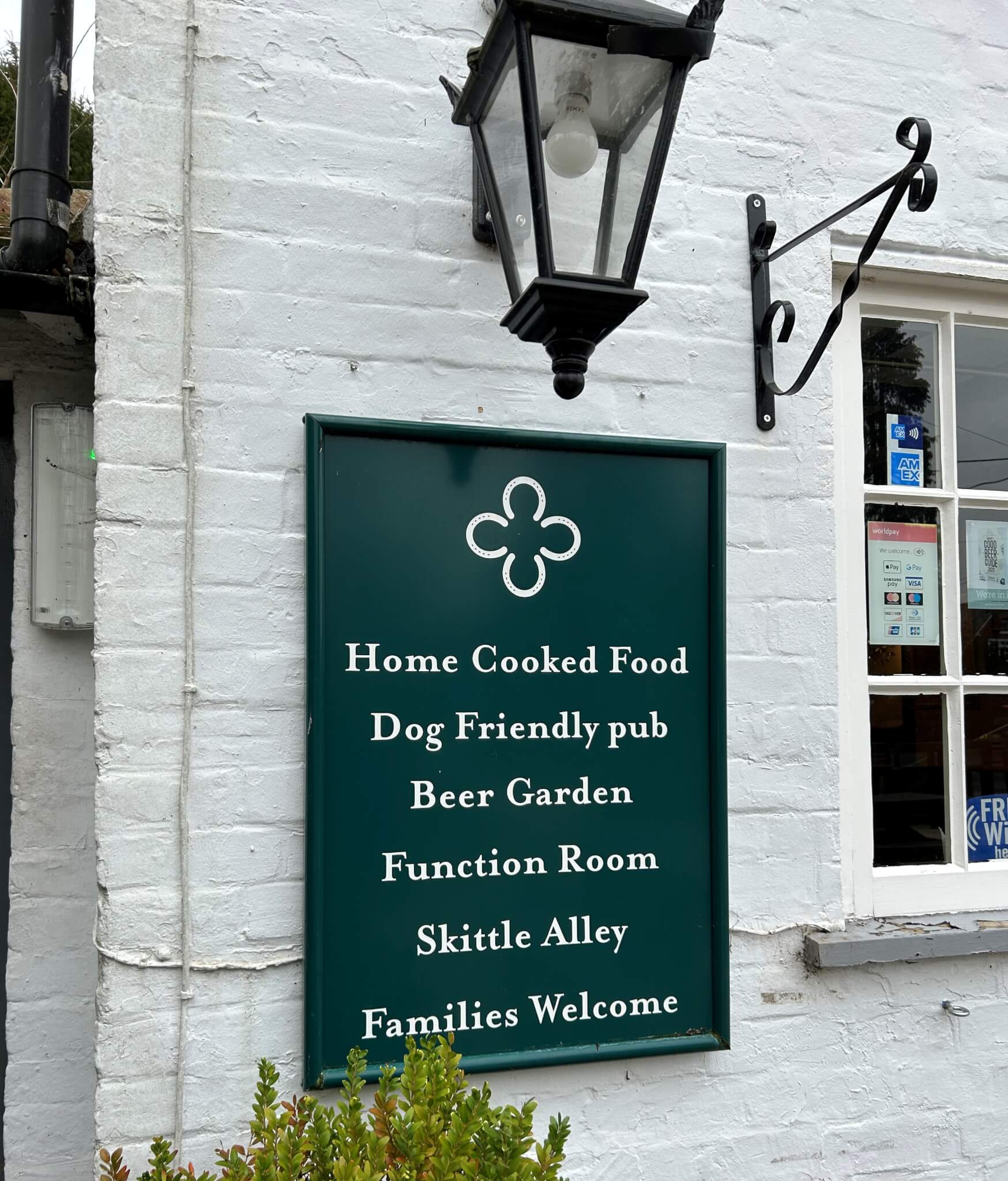 Home Instead Basingstoke picture of The Four Horseshoes Pub, showing their sign reading: "Home Cooked Food, Dog Friendly pub, Beer Garden, Function Room, Skittle Alley, Families Welcome