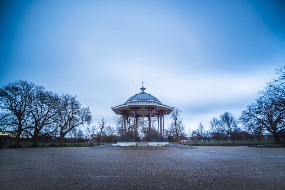 A gazebo in the center of a park, surrounded by bare trees and a cloudy sky. - Home Instead