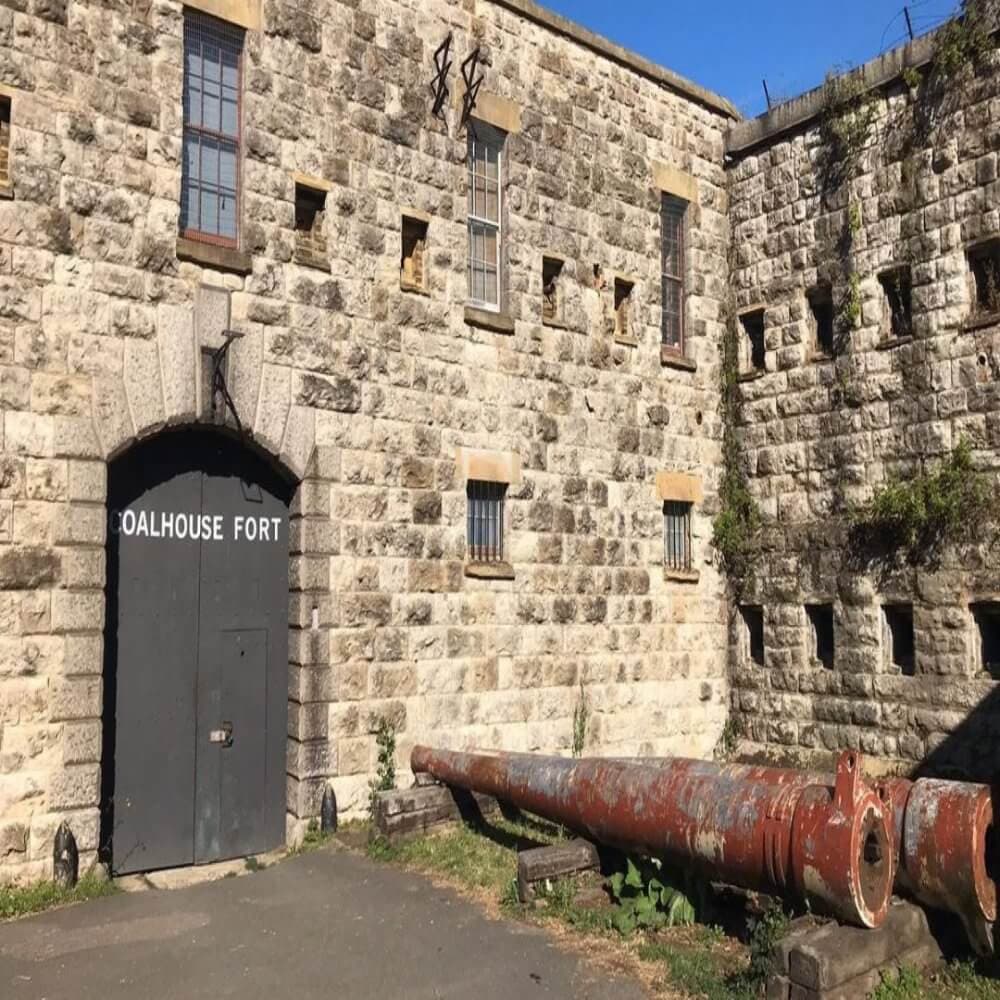 Stone-walled Coalhouse Fort with an old cannon lying horizontally in front of the entrance on a sunny day. - Home Instead