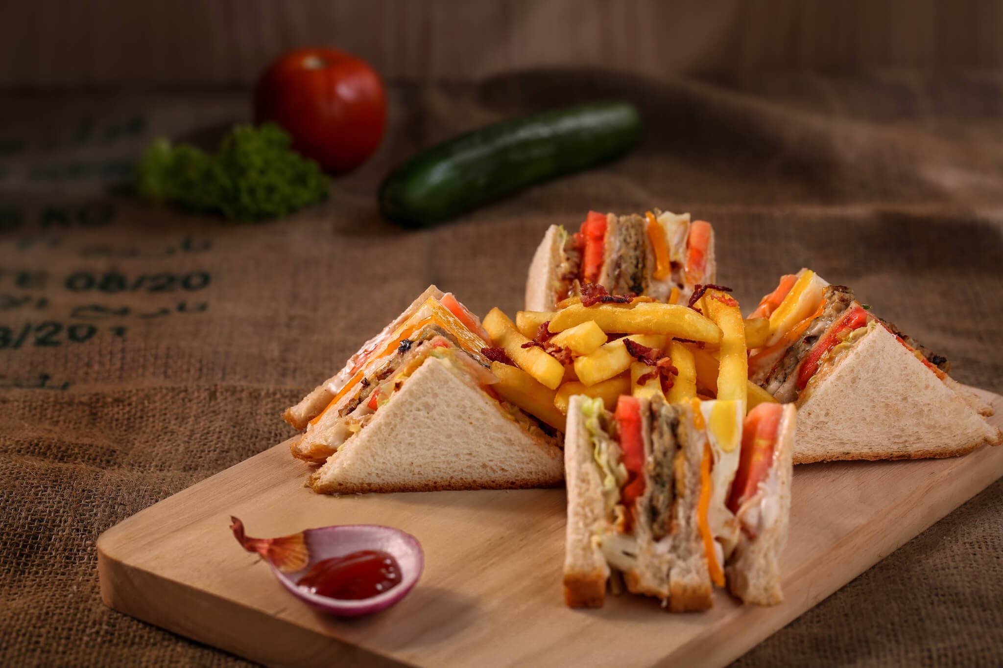 Triangular sandwiches with various fillings served on a wooden board with French fries and a dollop of ketchup. - Home Instead